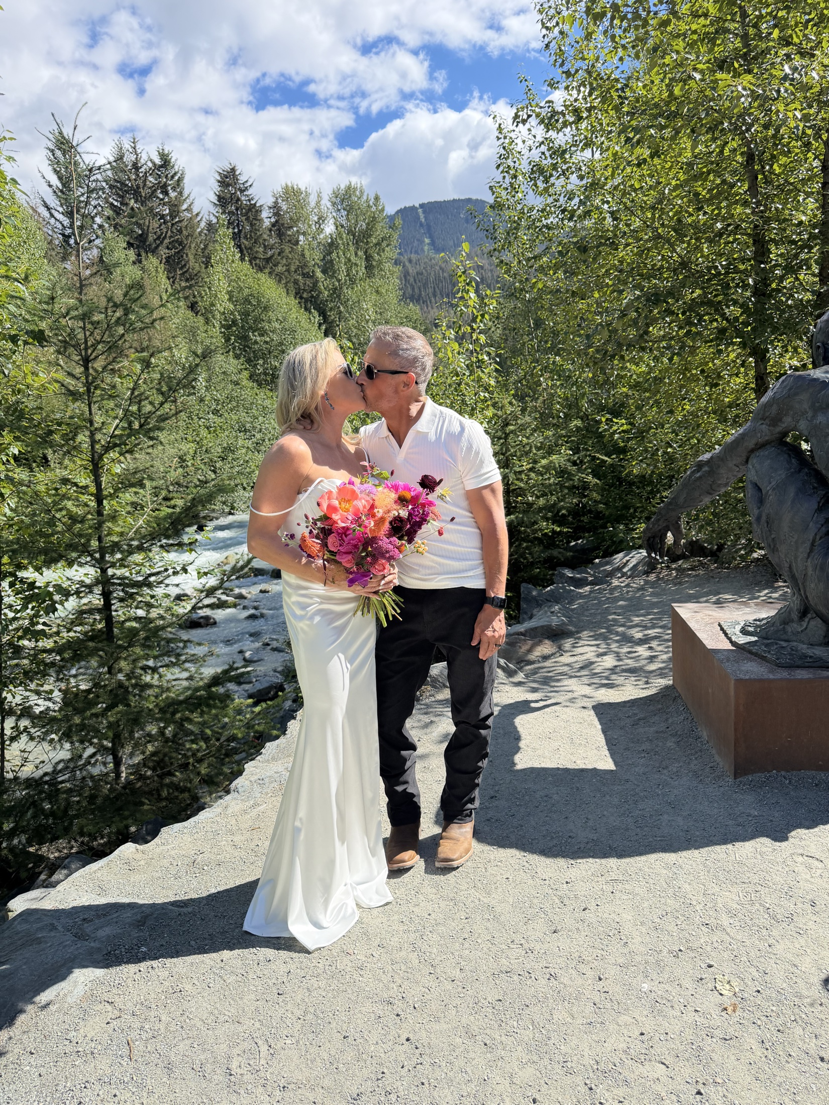 Deb and Daryl kissing beside the river in Whistler