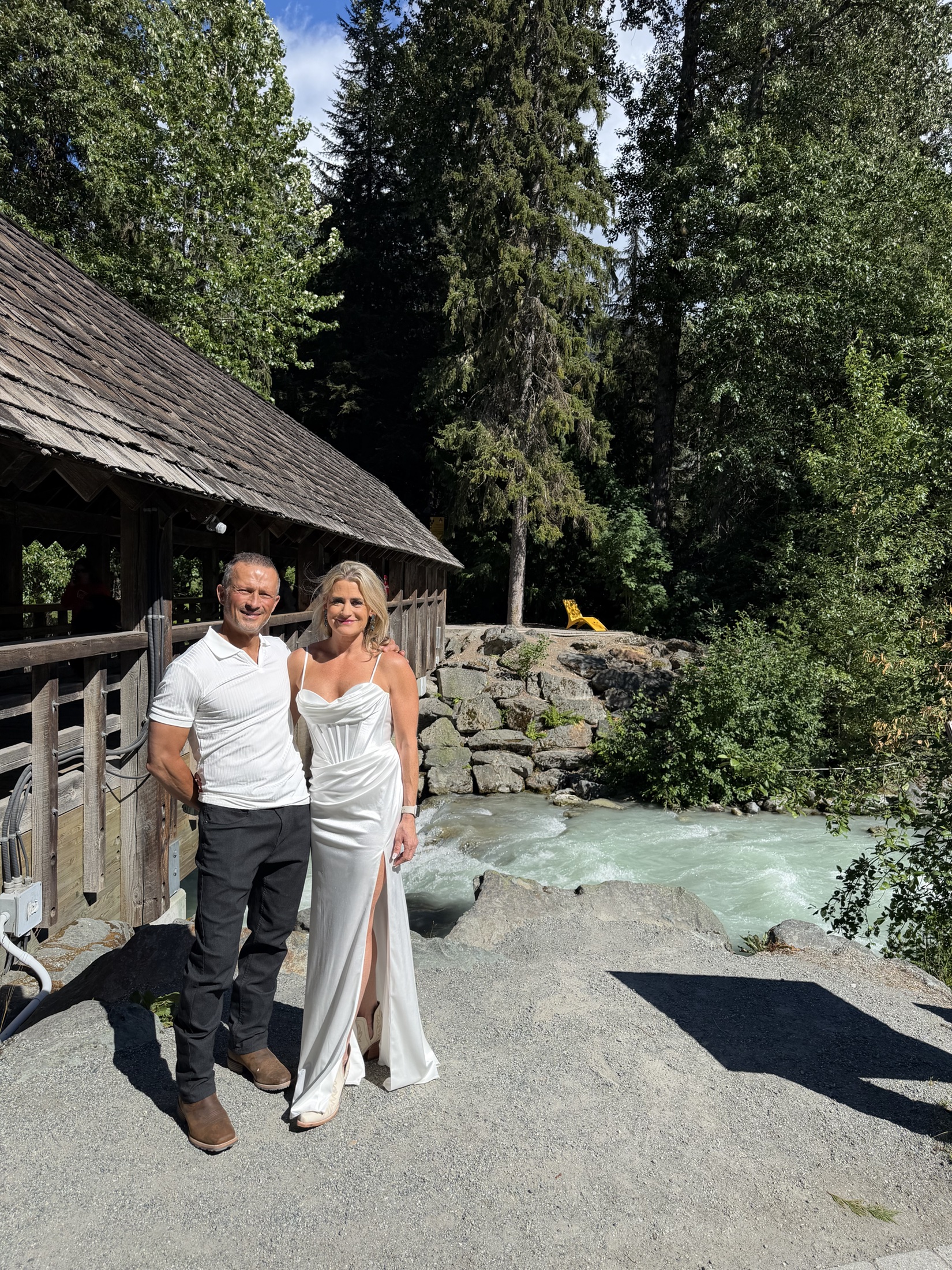 Deb and Daryl by a covered bridge and mountain river